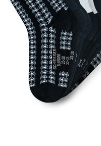 Șosete negre până la gleznă cu un model floral albastru și alb și marcaje de mărime 35-38 aranjate în fani pe un fundal alb.
