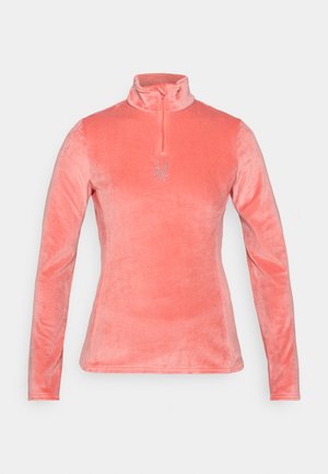 Coral velvet pullover with long sleeves, high collar, and a zipper. Features a reflective spider logo on the chest. Smooth texture.