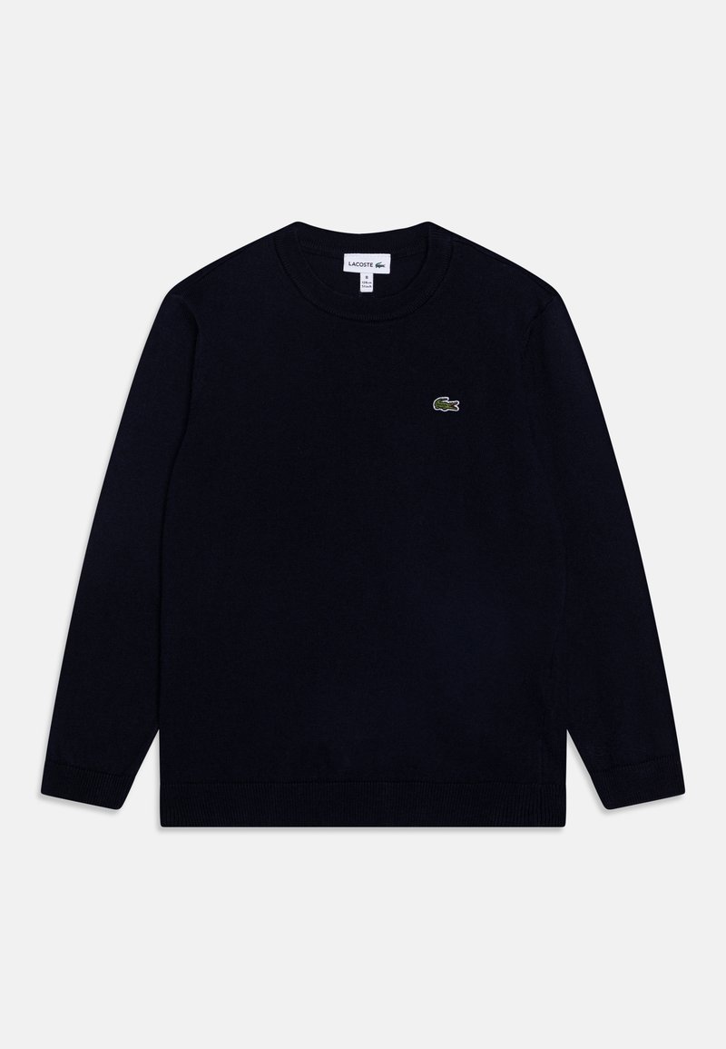 Mörkblå stickad tröja med rundad halsringning, långa ärmar och en liten grön krokodil-logotyp på bröstet. Ribbad mudd och nederkant.