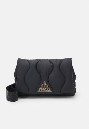 Sac à épaule matelassé noir avec motif de couture ondulé et plaque logo métallique triangulaire sur le devant sur fond blanc.