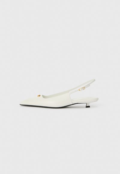 Witte leren slingback schoenen met een spitse neus, gouden hardware accent en een lage blokhak. Zachte textuur met uitsnijdingen.