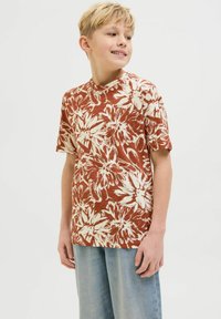 Camiseta de manga corta con un fondo color óxido y un patrón floral blanco. Fabricada con una tela ligera; escote redondo; corte relajado.