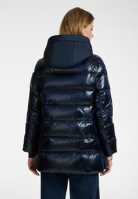 Giacca puffer blu navy con una finitura lucida, presenta un cappuccio, trapuntatura orizzontale e una vestibilità rilassata, che arriva sopra i fianchi.