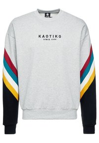 Felpa grigia con polsini a costine, presenta un logo nero "KAOTIKO" e strisce multicolori sulle maniche in tonalità blu mare, bordeaux, bianco e giallo.