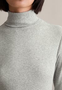 Fitted grijze ribbel turtleneck met een hoge hals, gemaakt van textuurstof, met subtiele verticale strepen.