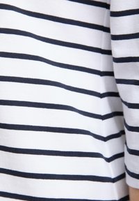 Katoenen langemouwen top met marineblauwe en witte horizontale strepen. Voorzien van een ronde hals en een zachte textuur, geschikt voor casual draag.