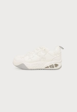 Hvid chunky sneaker med stjernemønstre, tekstureret sål, synlig luftpude i hælen og trækstrop bagpå.