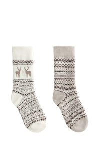 Para przytulnych wełnianych skarpetek z wzorem, jedna biała z motywem renifera, druga szara z odpowiadającymi nordyckimi geometrycznymi wzorami.