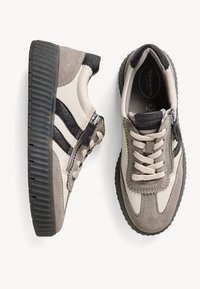 Sneaker beige e grigie con superficie texturizzata, dotate di chiusura con zip, strisce a contrasto e suola in gomma spessa.