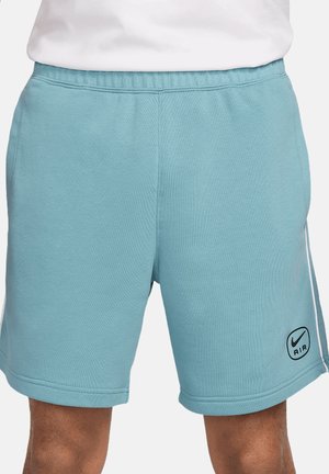 Light blue Nike shorts made of soft fabric, featuring an elastic waistband, side stripes, and a printed logo on the left leg.