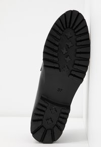 Svart gummistövel sål med djupt mönster och korsmönster, storlek 37. Slät yta med en lätt glans. Solid och hållbar design.