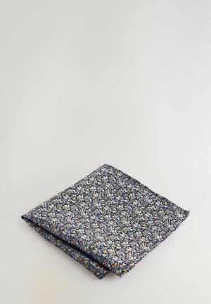 Marineblå blomsterlommeur med et tæt mønster af hvide, gule og røde blomster på et tekstureret stof, pænt foldet på halv.