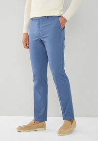 Lichtblauwe chino's gemaakt van stof met een gladde textuur, met een rechte pijpdesign, zijzakken en een knoopsluiting.