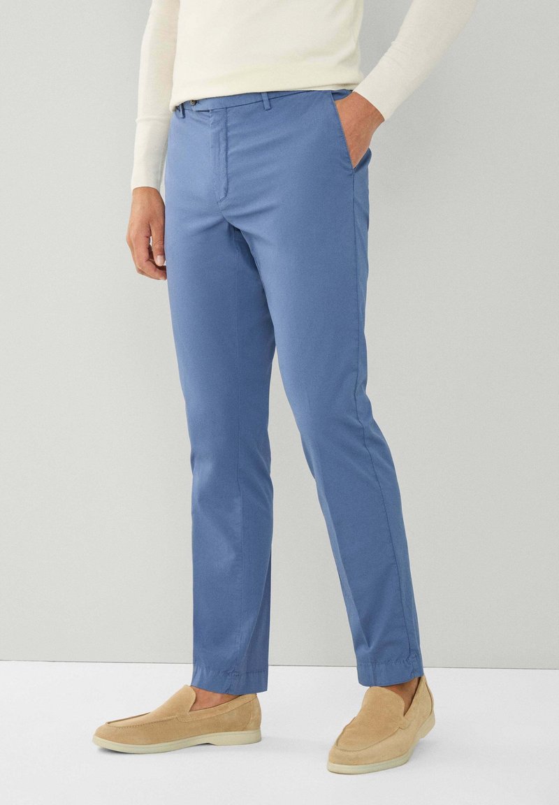 Lichtblauwe chino's gemaakt van stof met een gladde textuur, met een rechte pijpdesign, zijzakken en een knoopsluiting.