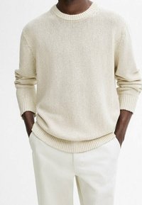 Pullover in maglia color beige chiaro con colletto e orlo a costine, dotato di maniche lunghe e vestibilità rilassata. Tessuto testurizzato.
