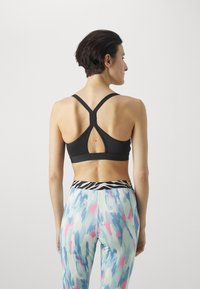 Puma KEEPS ULTRABARE STRAPPY - Vidutiniškai krūtinę prilaikanti sportinė liemenėlė - puma black