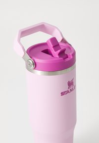 Pink stainless steel tumbler with a pink plastic lid and handle. Features a silicone straw opening and a silver accent near the top.