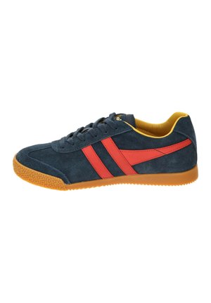 Navy blue suede sneaker with orange sole, red stripes on the side, navy laces, and yellow interior lining.