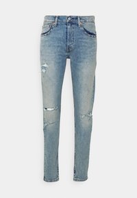 Ljust blå denimjeans med slim fit, försedd med slitna hål vid knäna, klassisk femficksdesign och metallknappsstängning.