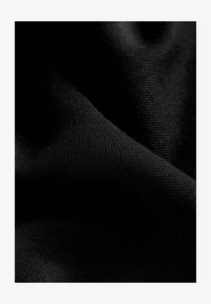 Melnā auduma ar teksturētu austu, redzamas mīkstas, drapētas krokas. Tam ir gluda virsma un dziļa, vienota krāsa.