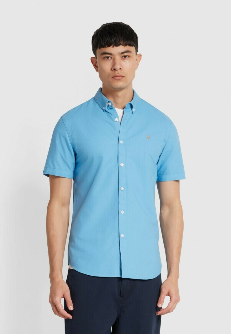 Lichtblauw kortebloemig overhemd met knoopsluiting en kraag, met een klein logo op de borst, gemaakt van gladde stof, slim-fit.