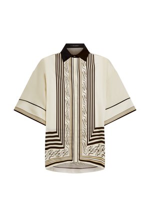 Chemise crème à manches courtes avec col noir, comportant des lignes noires verticales, des accents dorés et des motifs de texte stylisés sur toute la surface.