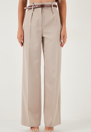 Beige wijde broek met plooien, een ceintuur in een gestructureerd bruin materiaal en een gladde afwerking. Gedetailleerd met een ritssluiting en voorplooien.