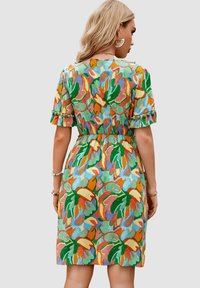 Vestido floral colorido de algodón con cintura ajustada. Presenta mangas cortas de globo, patrones en verde, naranja, rosa y azul. Bordes de mangas con volantes.