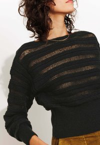 Pull en maille noire avec des rayures texturées horizontales ; présente un col bateau et des poignets côtelés. Légèrement transparent et léger.