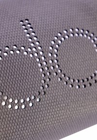 Textil gris con un patrón de malla que presenta detalles punteados formando la palabra "do" en blanco, destacando su textura transpirable y diseño.