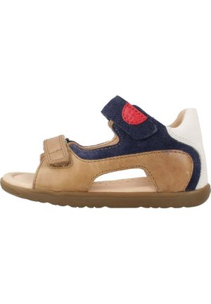 Sandale marron et marine avec sangle Velcro, design ouvert, en cuir souple, semelle intérieure rembourrée et accent rouge sur la sangle.