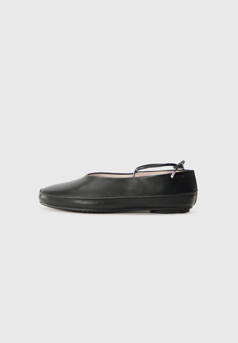 Ballerine nere in pelle con punta arrotondata, cinturino alla caviglia e superficie liscia. Presentano decorazioni minime e una suola in gomma flessibile.