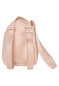 Mjukt rosa väska med rundad form, tygmaterial, justerbara canvasremmar och en slät yta. Har en diskret sidoknäppning med dragkedja.