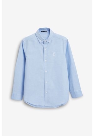 Chemise boutonnée bleu clair à manches longues, avec un col et un ourlet arrondi. Présente un petit logo de cerf brodé en blanc sur la poitrine.