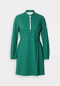 Πράσινο φόρεμα με μακριά μανίκια, φερμουάρ στον λαιμό τύπου mock neck, σφηνοειδής μέση και διαμάντι μοτίβο με λευκές λεπτομέρειες. Κατασκευασμένο από ελαφρύ ύφασμα.