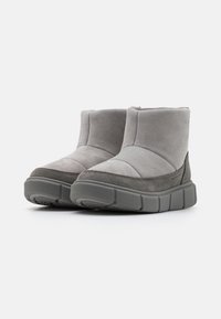 Grå ankelstøvler laget av myk semsket skinn med et strukturert design og en tykk, polstret såle for komfort. Har sømløs søm og rund tå.