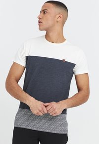 T-shirt med korte ærmer, der har en crème farvet overdel, navy midte og et mønstret grå nederste kant, fremstillet af blødt bomuldsblandingsstof.