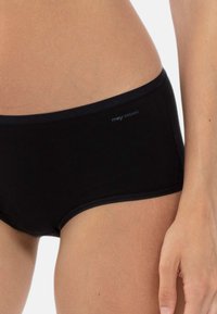 Culotte de bikini en coton biologique noir avec une texture lisse et une taille large, arborant un logo de marque subtile en bleu sur le côté.