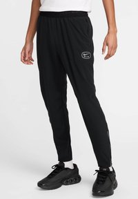 Pantalons de sport noirs ajustés, dotés d'une taille élastique, de poches latérales et d'un petit logo sur la cuisse gauche.