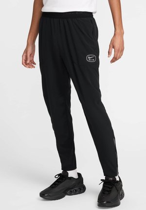 Pantalons de sport noirs ajustés, dotés d'une taille élastique, de poches latérales et d'un petit logo sur la cuisse gauche.
