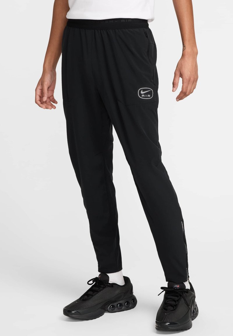 Pantalons de sport noirs ajustés, dotés d'une taille élastique, de poches latérales et d'un petit logo sur la cuisse gauche.
