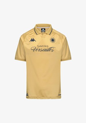 Polo jaune avec le texte « Football Club de Versailles », emblème du soleil, logo Kappa et bordure noire au col.