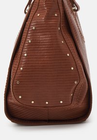 Braune Handtasche mit Krokodilprägung, verziert mit goldenen Nieten als Akzente und einer weichen, strukturierten Form.