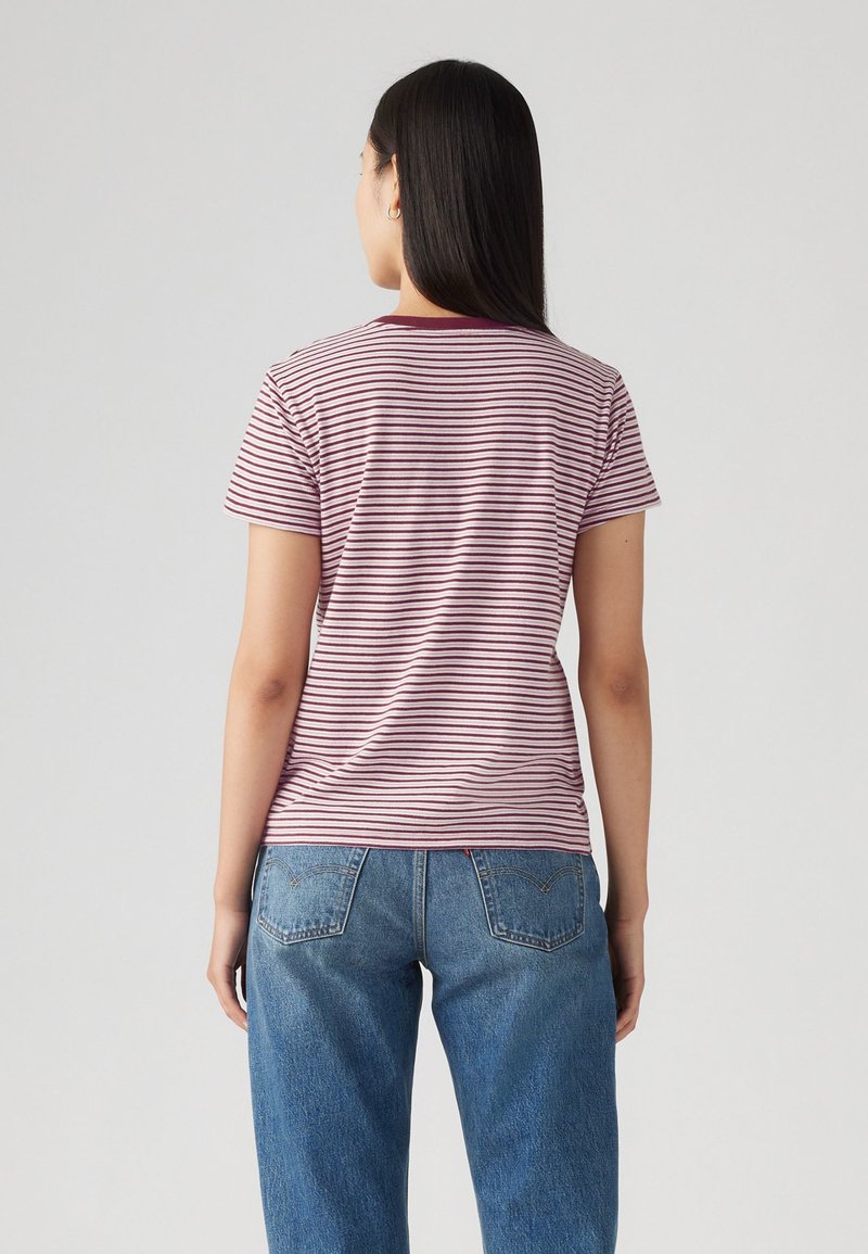 Rot-weißer gestreifter Baumwoll-T-Shirt mit einem einfarbigen burgunderfarbenen Kragen, kurzen Ärmeln, getragen mit blauen Denim-Jeans. Einfaches, lässiges Design.