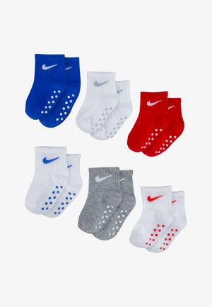 Three pairs of cotton socks in blue, red, gray, and white. Each sock features a logo and rubber dots on the sole for grip.