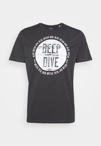 Camiseta de algodón negra con un diseño gráfico circular que presenta el texto "DEEP DIVE" y una textura desgastada. Manga corta y cuello redondo.