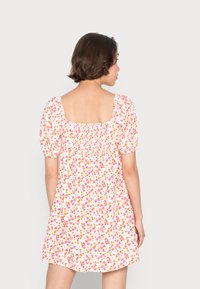 Vestido de mangas curtas, com padrão floral, com costas quadradas, apresentando flores cor-de-rosa e laranja num fundo branco, tecido leve e cintura franzida.