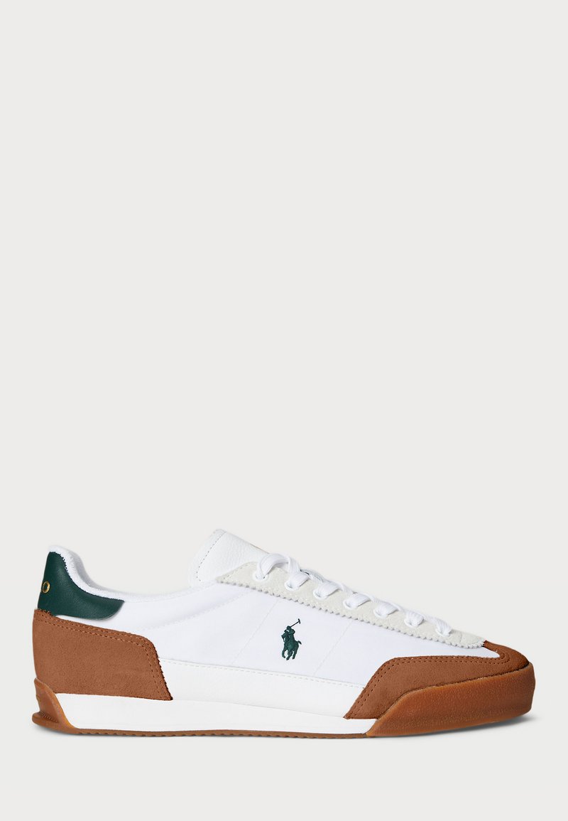 White sneaker with brown suede accents, green heel tab, and white laces. Features a side logo and a textured rubber sole.