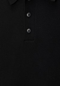 Polo en maille noire avec trois boutons noirs sur la patte de boutonnage et une texture côtelée.
