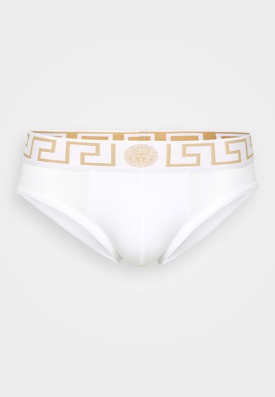 Boxers brancos de algodão com uma cintura em padrão geométrico dourado e um emblema central. Textura suave com um ajuste confortável.